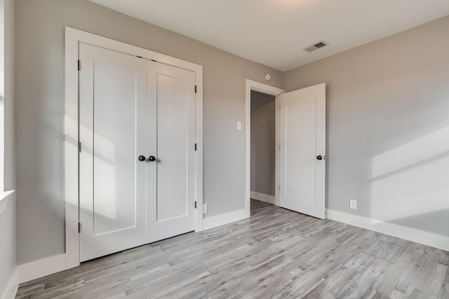 unfurnished bedroom featuring a closet and light hardwood / wood-style floors