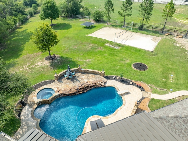 view of swimming pool with an in ground hot tub, volleyball court, a rural view, and a lawn