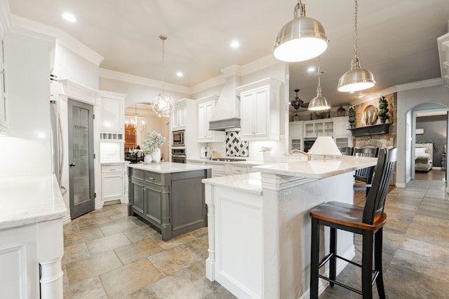 kitchen with premium range hood, gray cabinetry, hanging light fixtures, white cabinets, and a kitchen island