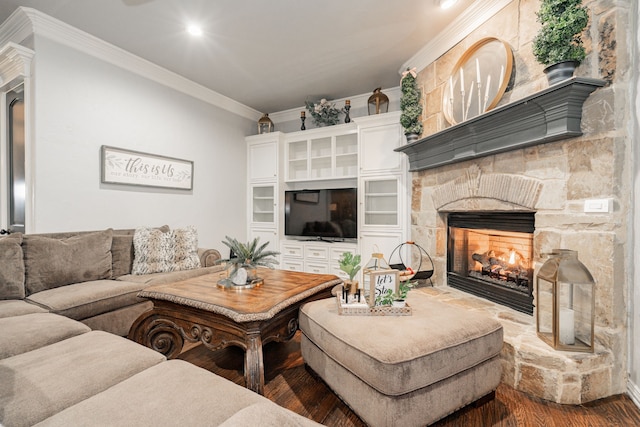 living room featuring crown molding, a stone fireplace, and wood-type flooring