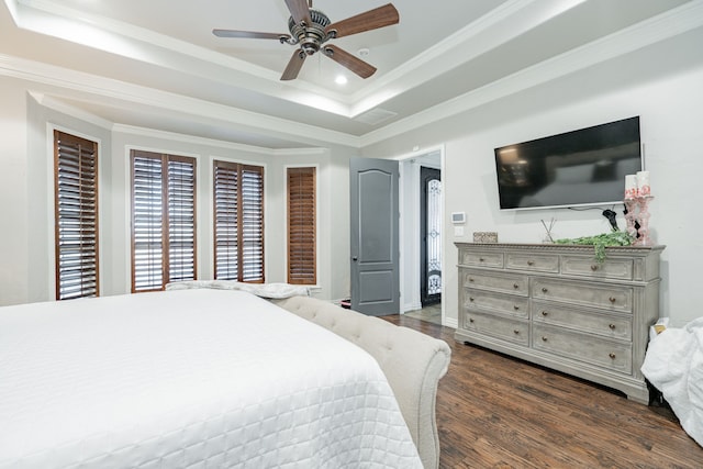 bedroom with a tray ceiling, ornamental molding, dark hardwood / wood-style floors, and ceiling fan