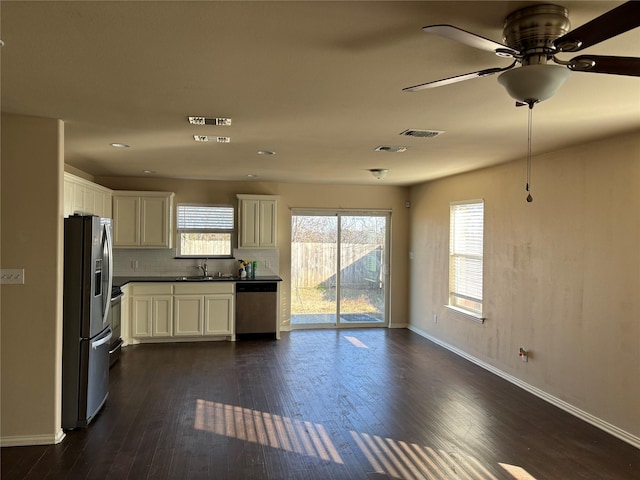 kitchen with tasteful backsplash, dark hardwood / wood-style floors, sink, white cabinetry, and stainless steel appliances