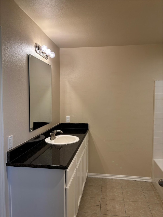 bathroom featuring a tub, a textured ceiling, tile patterned floors, and vanity