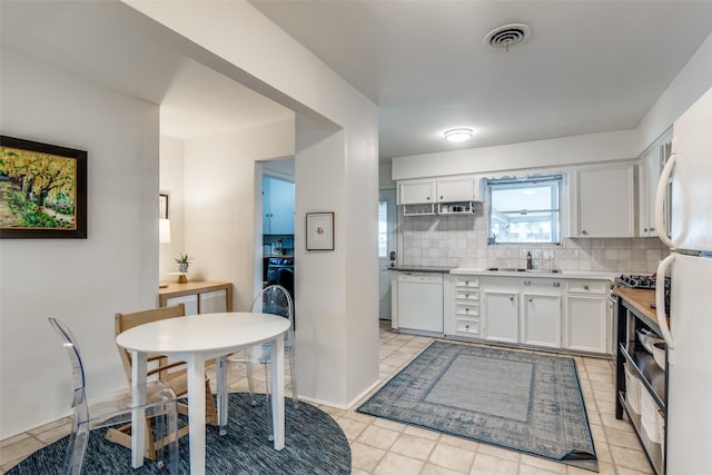 kitchen with dishwasher, white cabinetry, decorative backsplash, sink, and light tile patterned floors