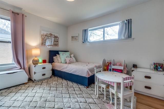 bedroom featuring light wood-type flooring and multiple windows