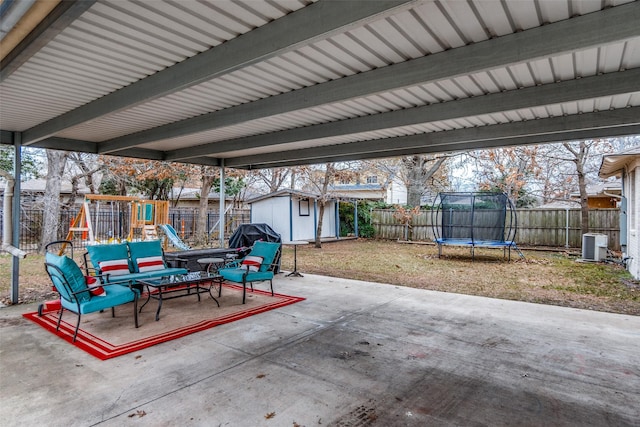 view of patio featuring a playground, a trampoline, a shed, and central air condition unit