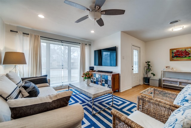 living room featuring ceiling fan, a wealth of natural light, and light hardwood / wood-style floors