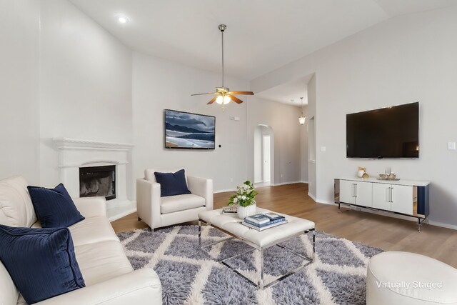 unfurnished living room featuring lofted ceiling, hardwood / wood-style flooring, and ceiling fan