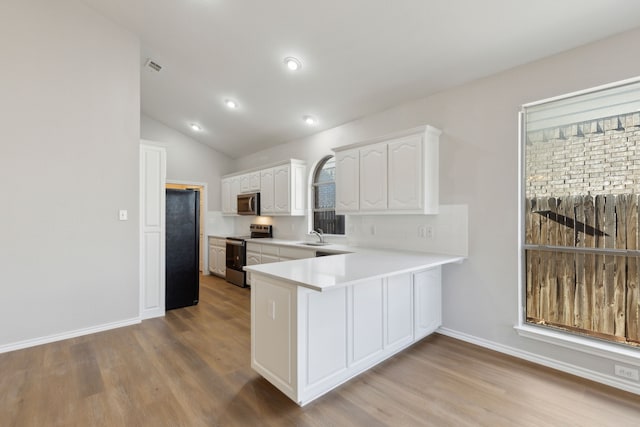 kitchen with sink, light hardwood / wood-style flooring, appliances with stainless steel finishes, kitchen peninsula, and white cabinets