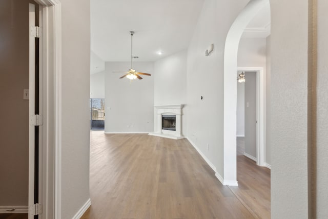 unfurnished living room with high vaulted ceiling, ceiling fan, and light hardwood / wood-style flooring