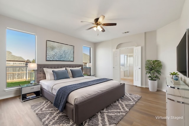 bedroom featuring hardwood / wood-style flooring, connected bathroom, and ceiling fan