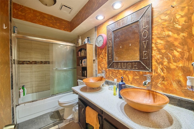 full bathroom with shower / bath combination with glass door, vanity, and toilet