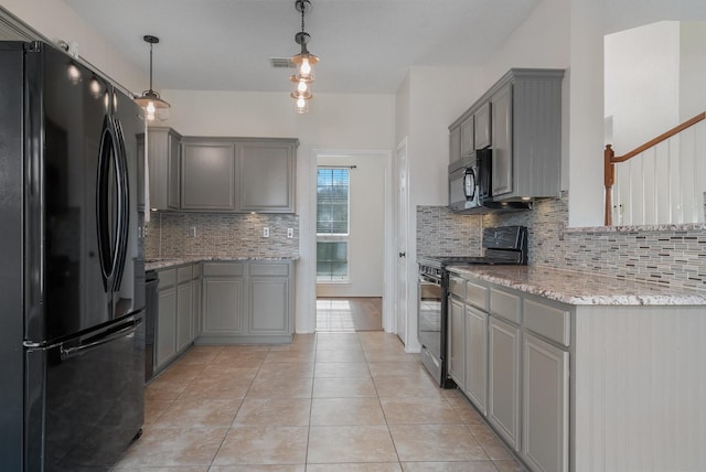 kitchen with gray cabinets, hanging light fixtures, black appliances, and tasteful backsplash