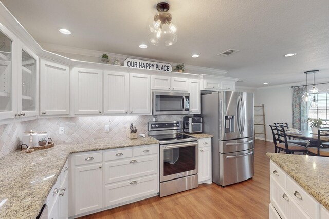 dining space featuring crown molding and light hardwood / wood-style flooring