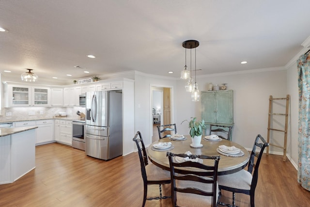 dining room featuring crown molding and light hardwood / wood-style floors