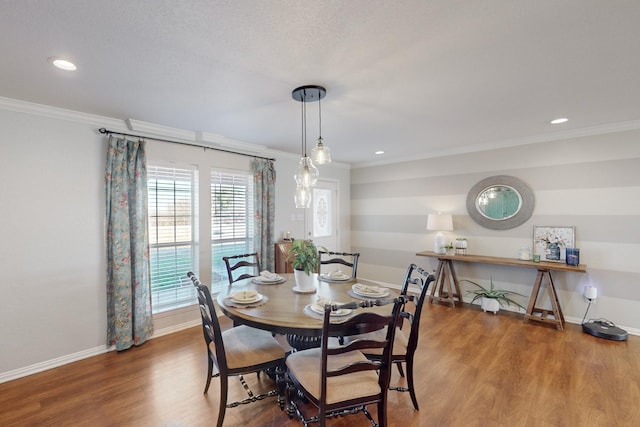 dining area with hardwood / wood-style flooring and crown molding