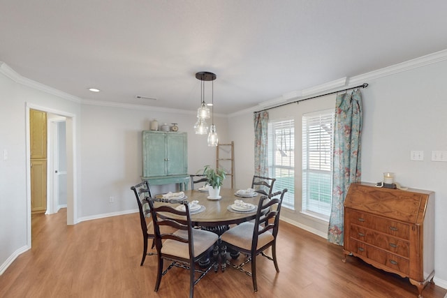 dining space featuring crown molding and light hardwood / wood-style flooring