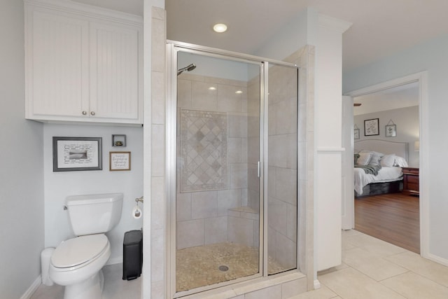 bathroom with a shower with shower door, tile patterned floors, and toilet