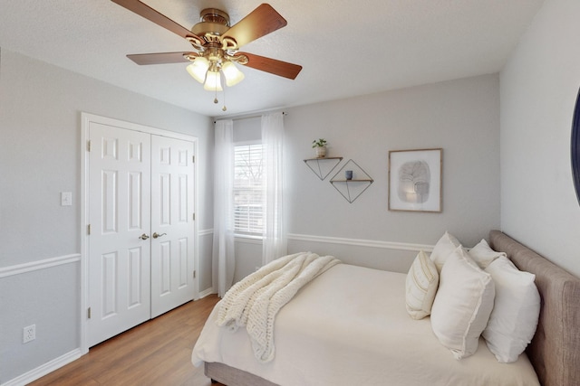 bedroom with wood-type flooring, a closet, and ceiling fan