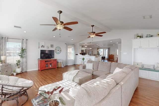 living room featuring plenty of natural light, hardwood / wood-style floors, and vaulted ceiling with beams