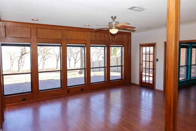 unfurnished room with a textured ceiling, ceiling fan, and dark hardwood / wood-style flooring