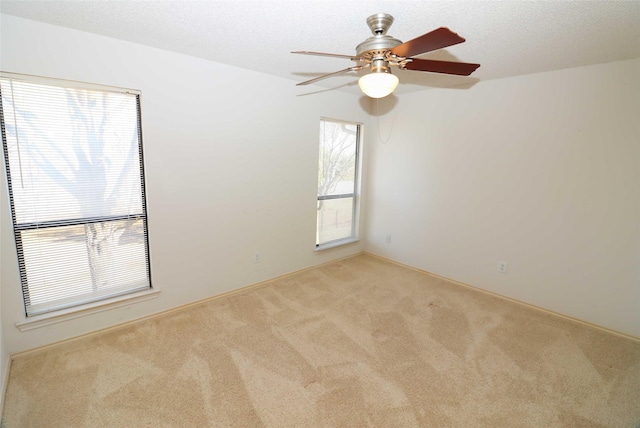 unfurnished room with a textured ceiling and light carpet