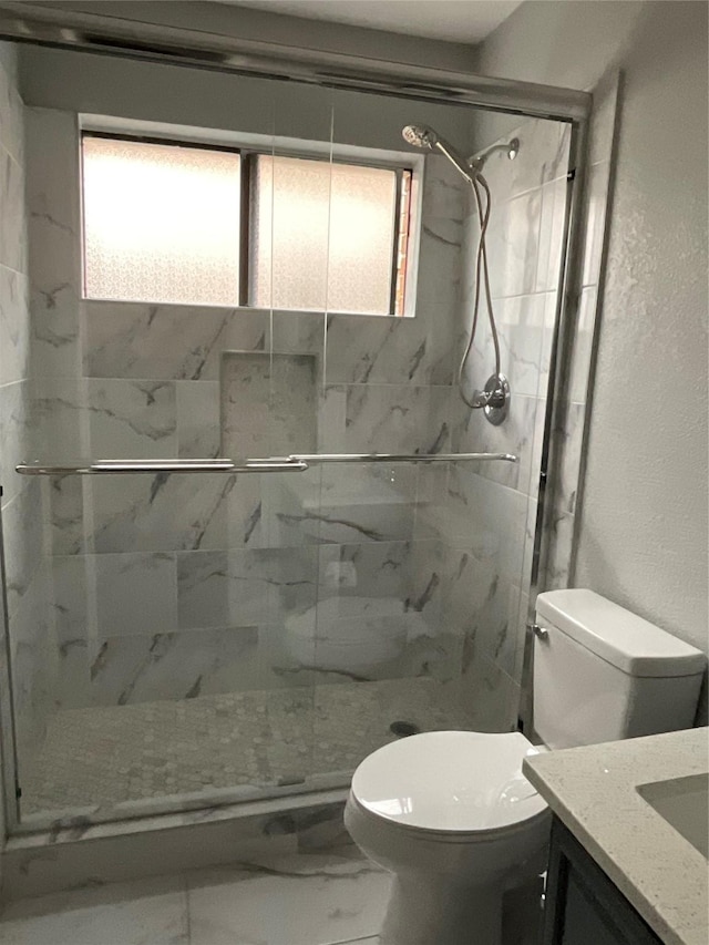 bathroom with toilet, a wealth of natural light, tiled shower, and vanity