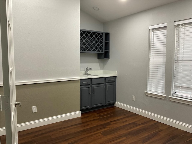 interior space featuring lofted ceiling, dark hardwood / wood-style flooring, sink, and gray cabinets