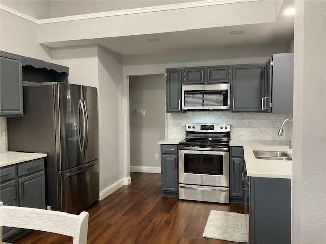 kitchen featuring appliances with stainless steel finishes, gray cabinetry, tasteful backsplash, and sink