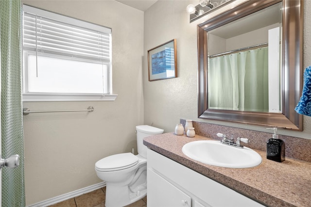 bathroom with toilet, vanity, and tile patterned floors