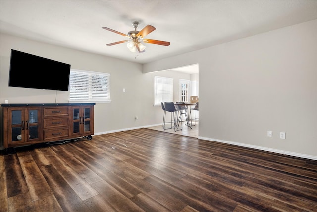 living room featuring ceiling fan, plenty of natural light, and dark hardwood / wood-style floors