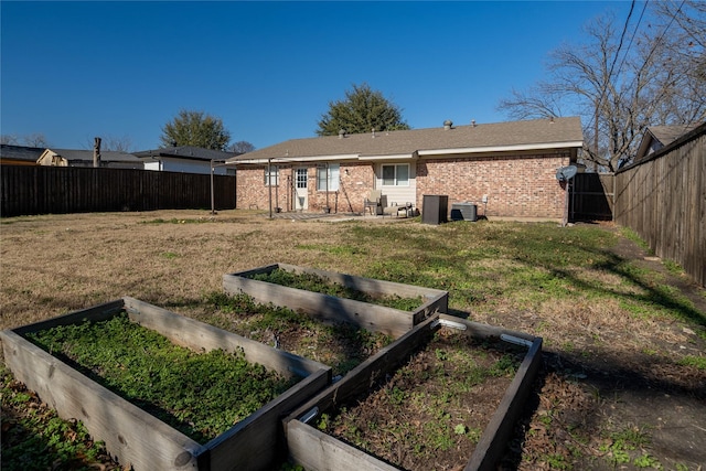 back of property featuring central air condition unit and a lawn