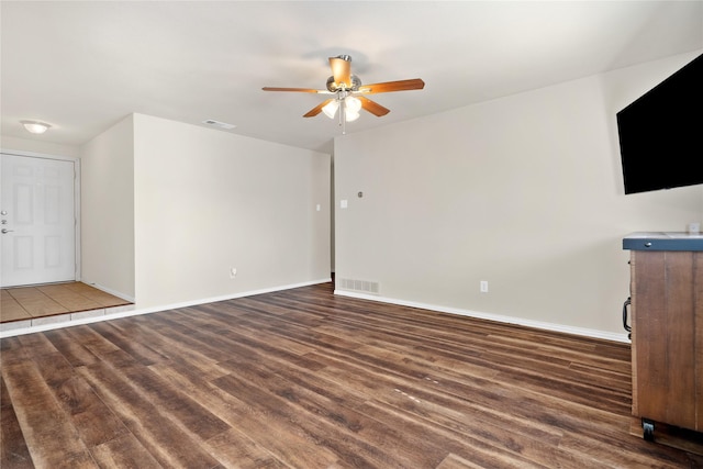 unfurnished living room with ceiling fan and dark hardwood / wood-style flooring