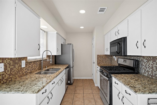 kitchen with white cabinetry, stainless steel appliances, backsplash, light stone counters, and sink