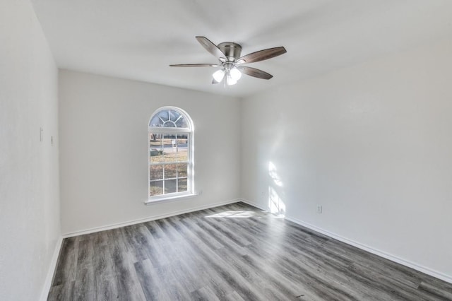 empty room with dark wood finished floors, baseboards, and ceiling fan