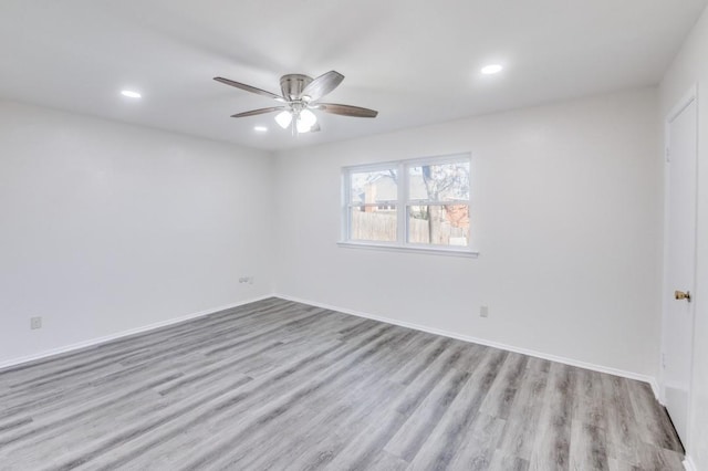 spare room featuring light wood finished floors, baseboards, a ceiling fan, and recessed lighting