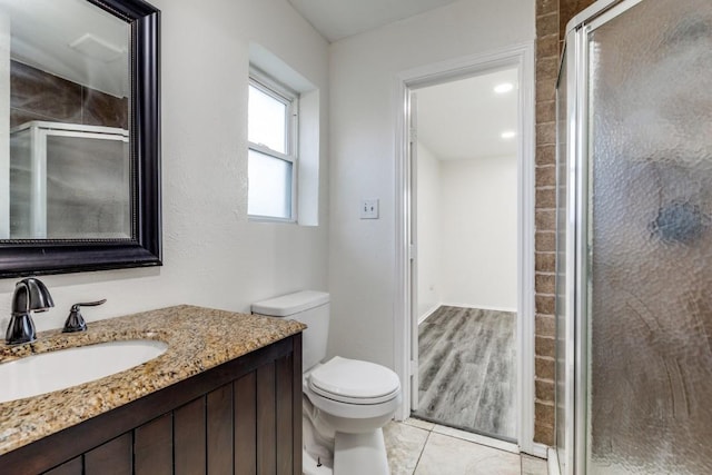 bathroom featuring toilet, tile patterned floors, a shower stall, and vanity