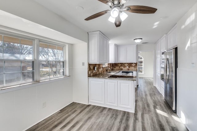 kitchen featuring stone countertops, stainless steel appliances, a sink, white cabinetry, and light wood-style floors