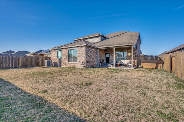 rear view of property with central AC unit, a patio area, and a lawn