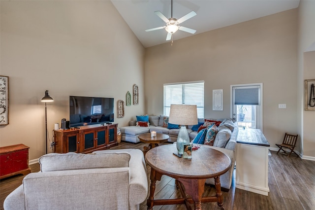 living room featuring dark wood-type flooring, high vaulted ceiling, and ceiling fan