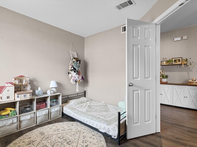 bedroom featuring wood finished floors and visible vents