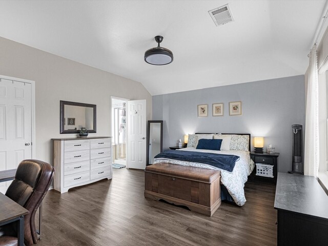 bedroom with dark wood finished floors, visible vents, ensuite bath, and vaulted ceiling