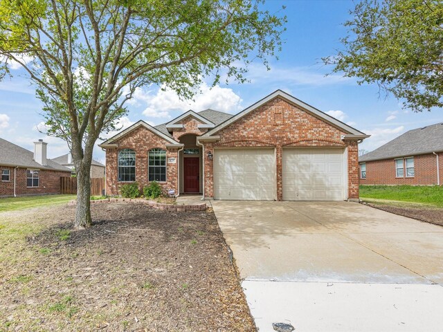 ranch-style house featuring driveway, fence, brick siding, and a garage