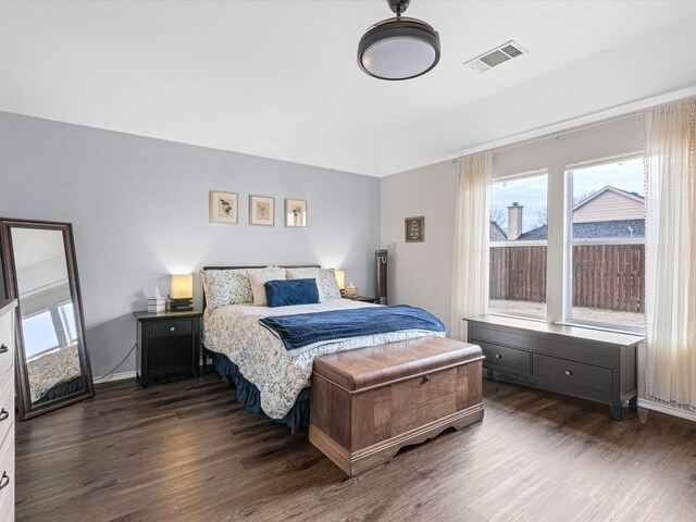 bedroom with dark wood-style flooring, visible vents, and baseboards