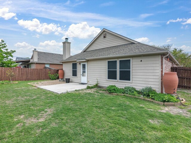 back of property with a patio, fence, a shingled roof, and a yard