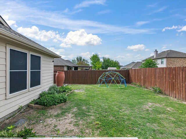 view of yard featuring a playground and a fenced backyard