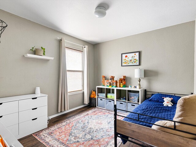 bedroom featuring baseboards and wood finished floors