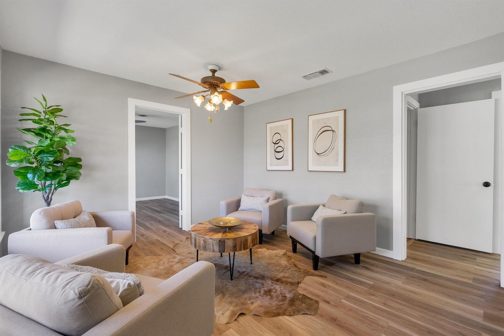 living room featuring ceiling fan and hardwood / wood-style flooring