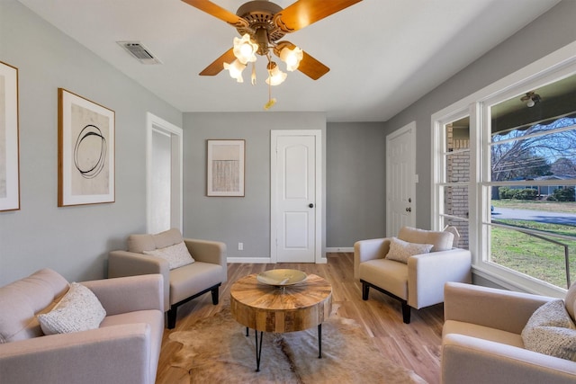 living room featuring ceiling fan and light hardwood / wood-style flooring