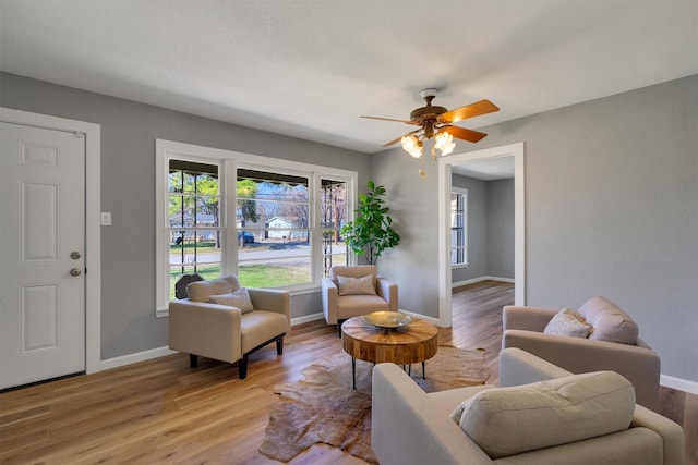 living room featuring ceiling fan and light wood-type flooring